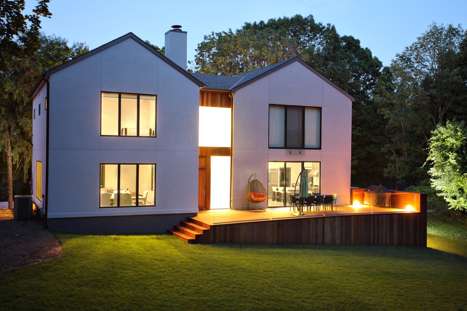 Beleuchtetes Wohnhaus mit Garten in der Abenddämmerung